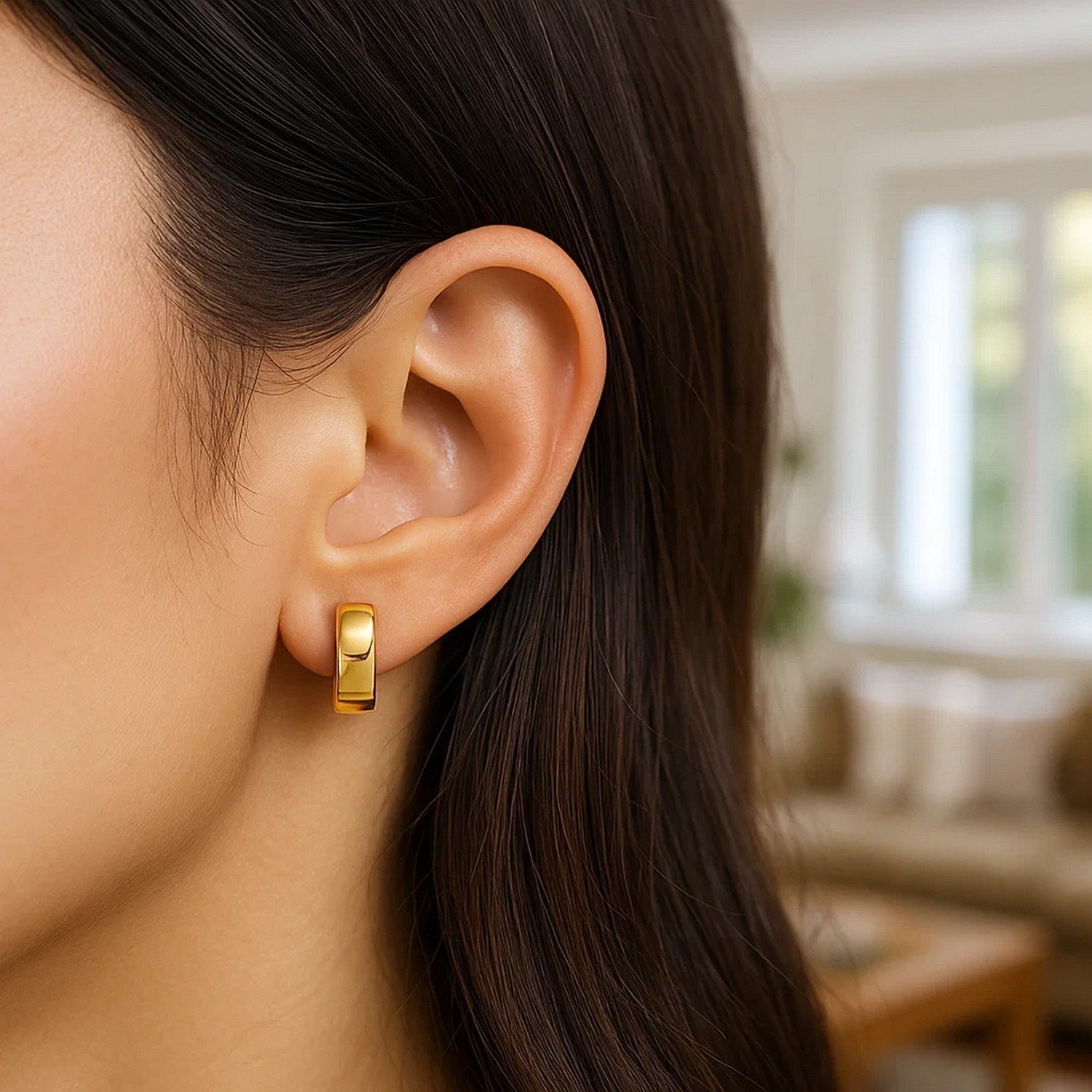 14k yellow gold snuggable hoop earrings on a person's ear.