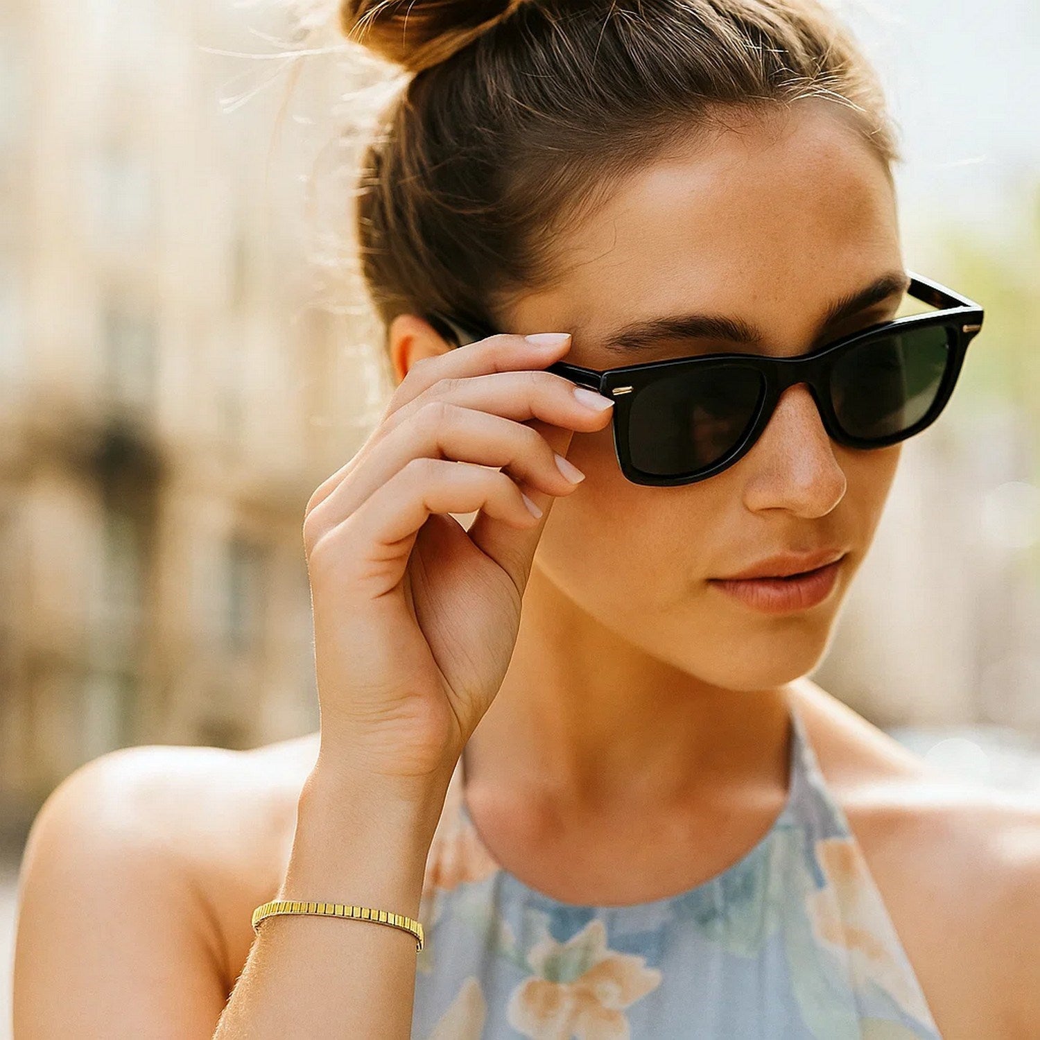 A woman wears a 14k yellow gold brick omega bracelet on her left wrist.
