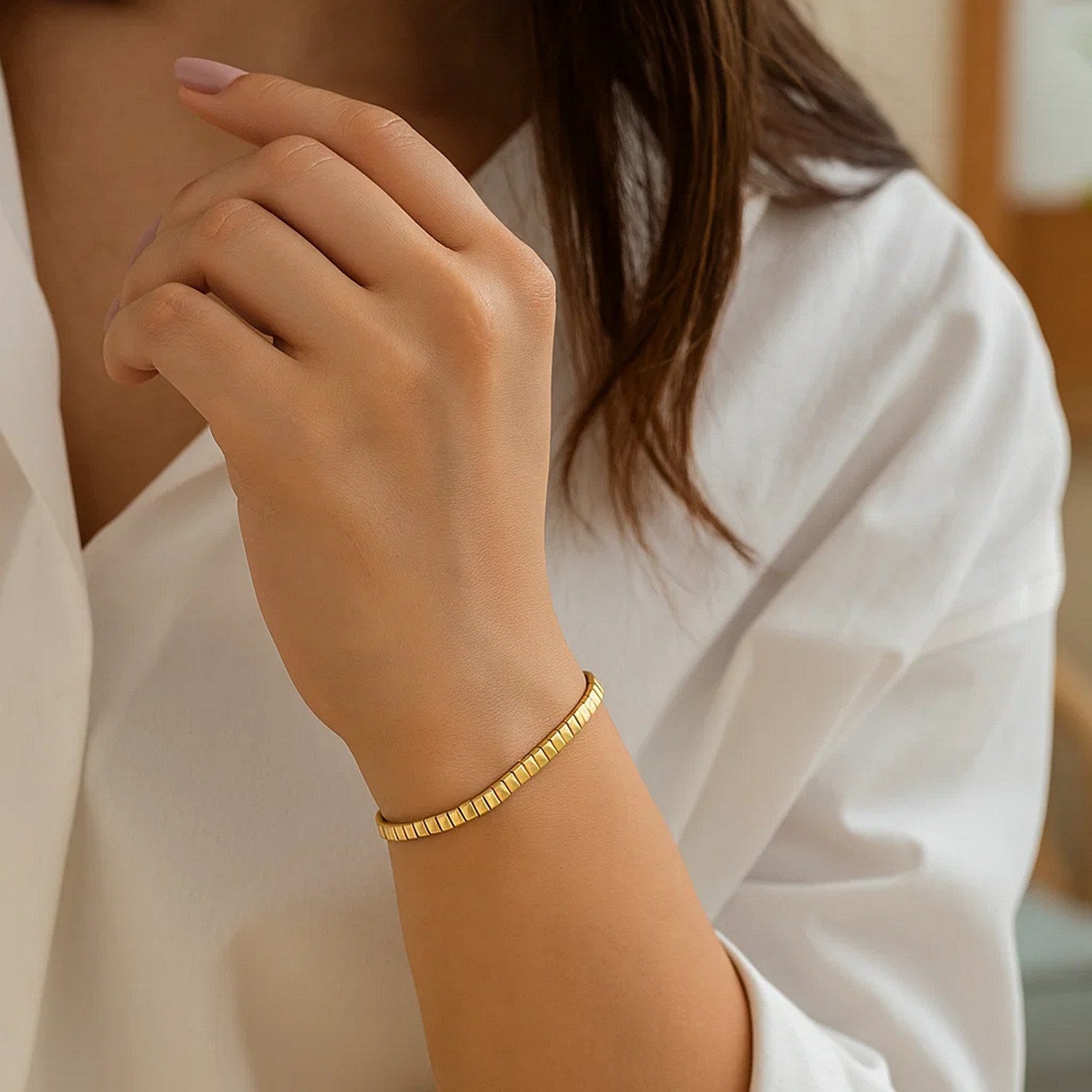 14k yellow gold brick omega bracelet on a woman's wrist.