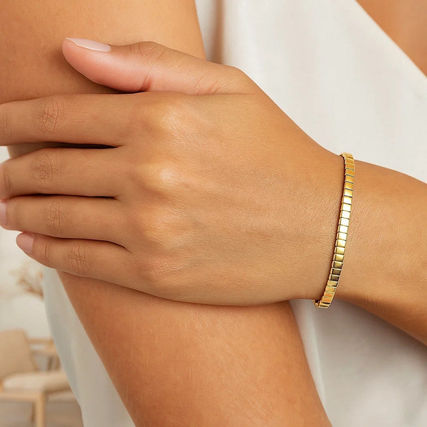 14k yellow gold brick omega bracelet on a woman's wrist.