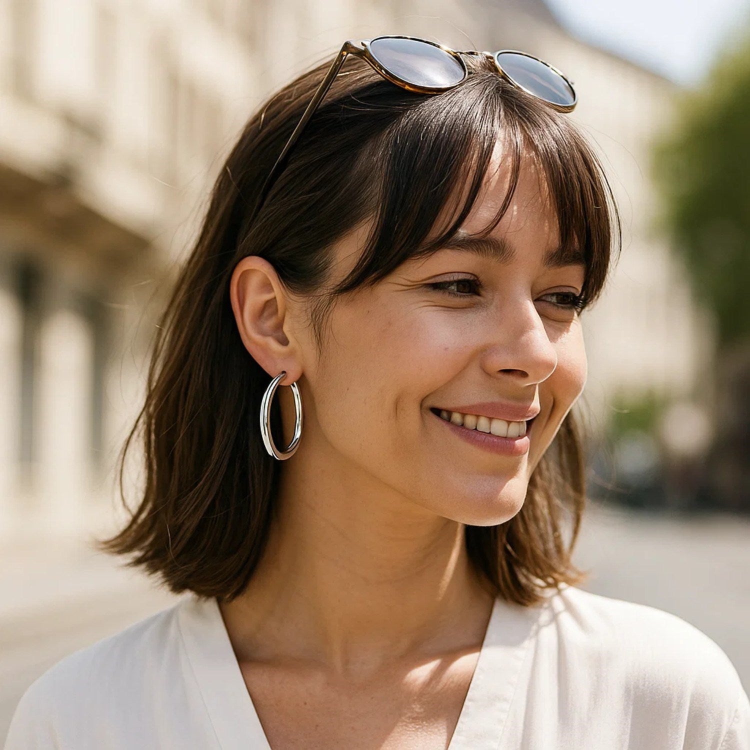 Sterling silver thick rhodium plated polished hoop earrings on a woman.