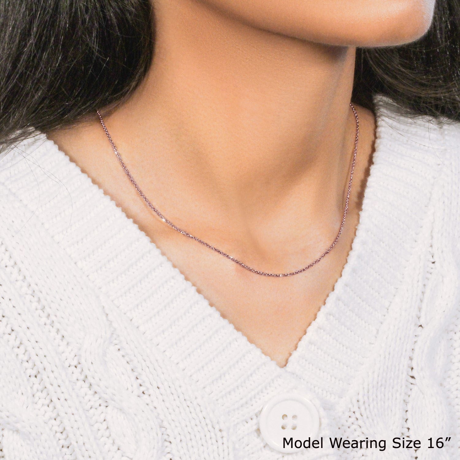 A 14k rose gold diamond-cut cable link chain is worn by a model.