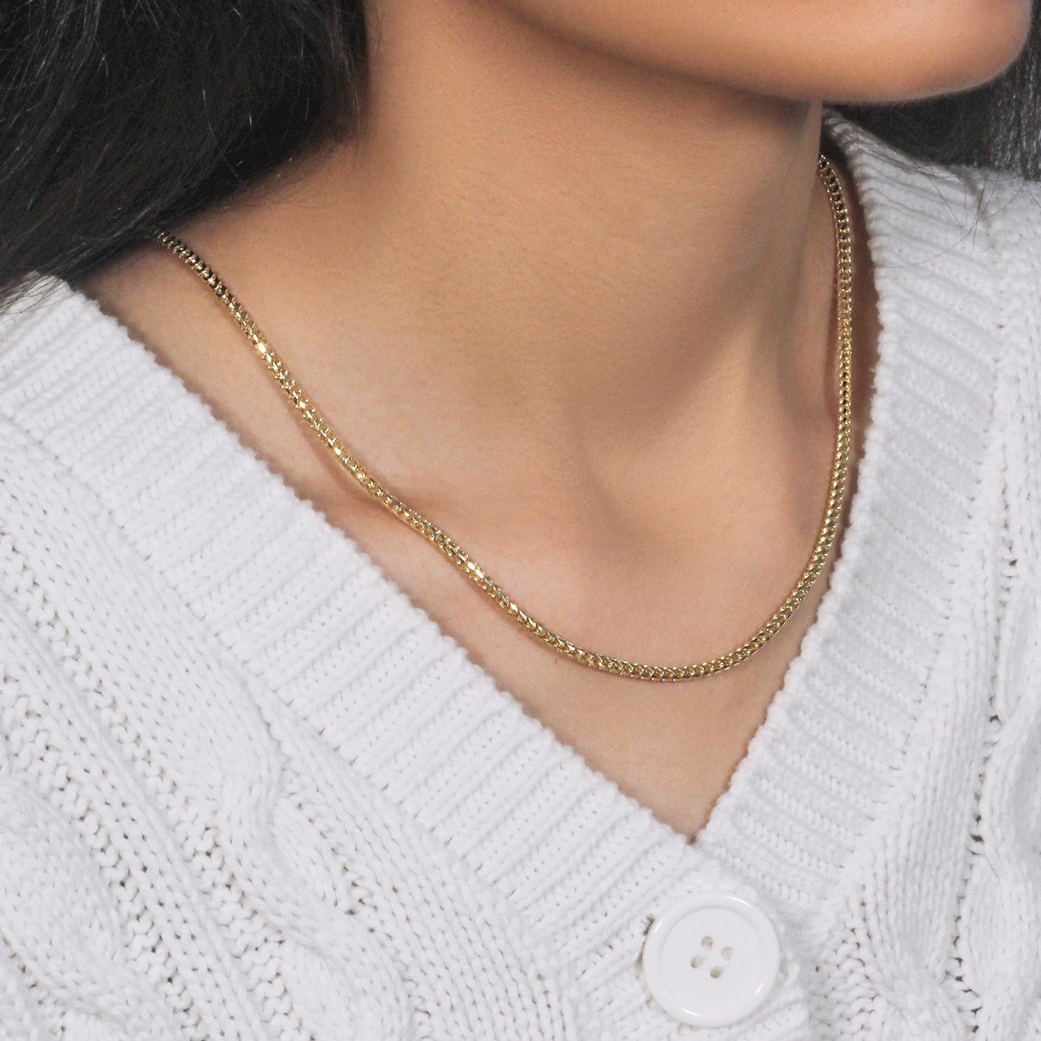 14k yellow gold diamond cut round Franco chain on a person wearing a white sweater.