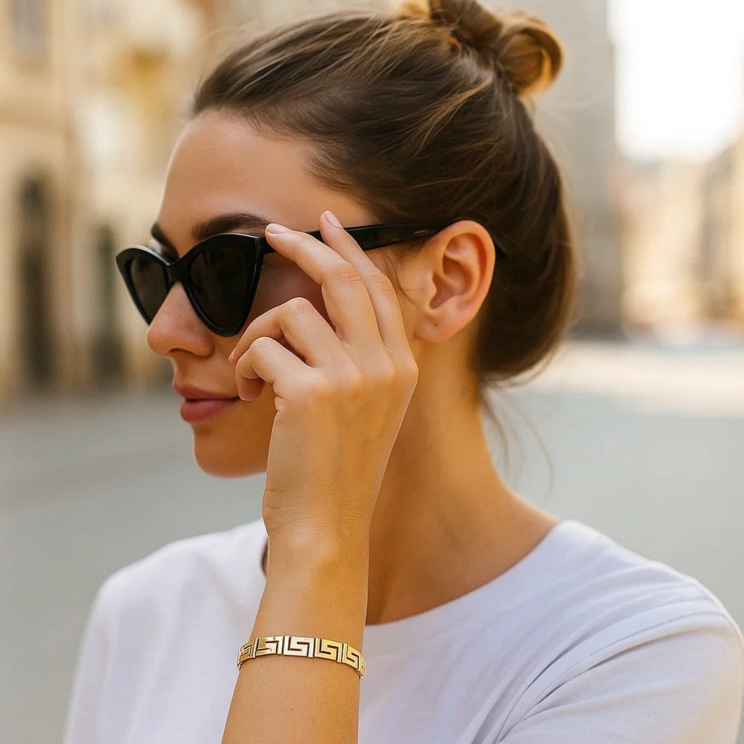 14k yellow gold Greek key motif bracelet on a woman's wrist.