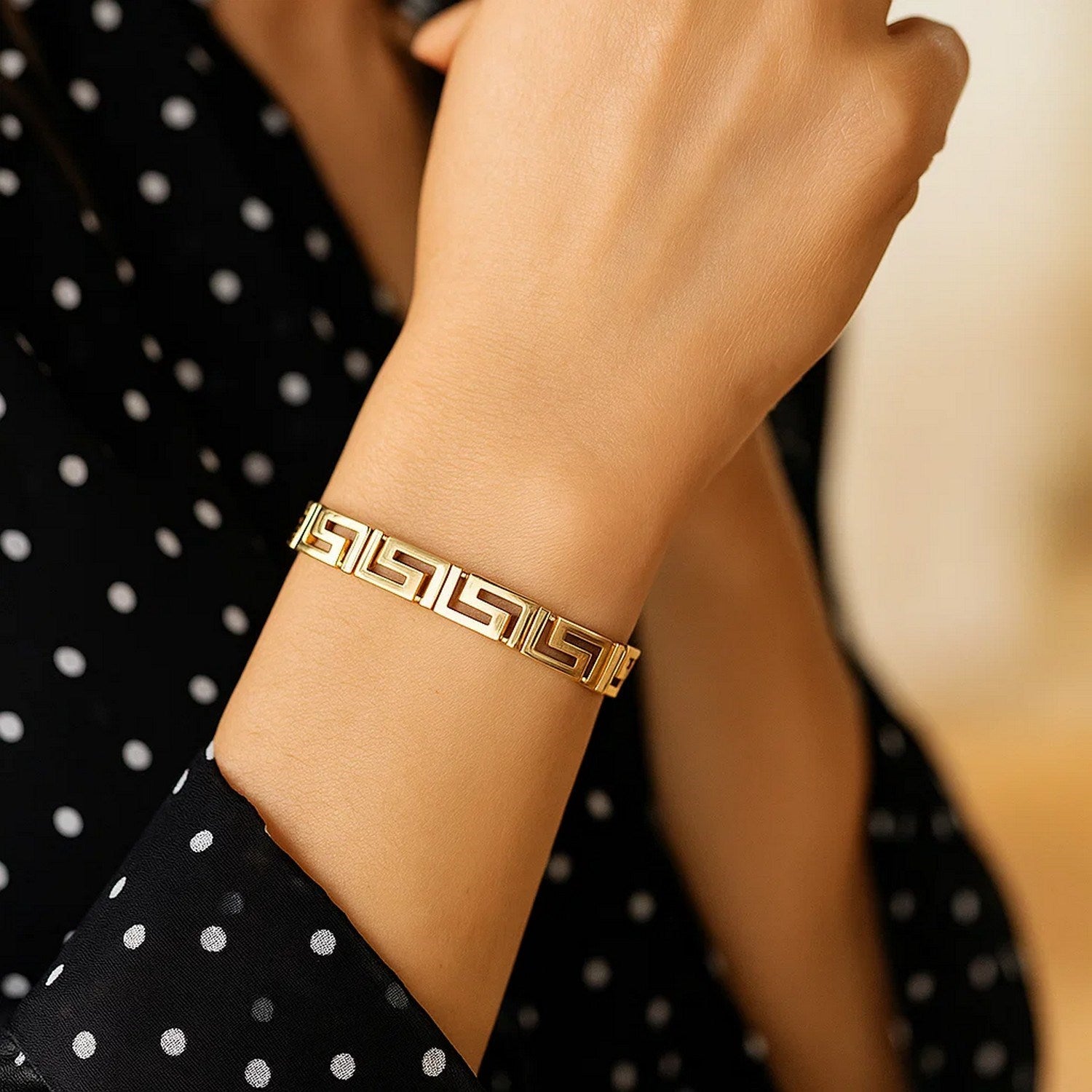 14k yellow gold Greek Key motif bracelet on a person's wrist.