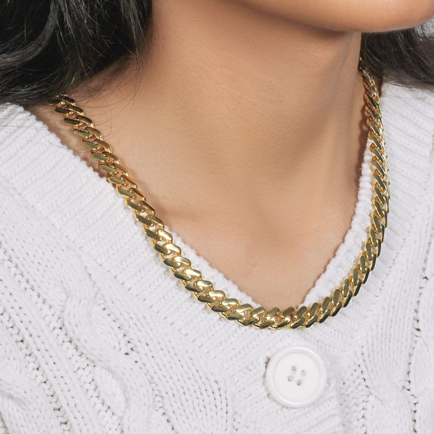 14k yellow gold 22-inch polished curb chain necklace on a person wearing a white sweater.