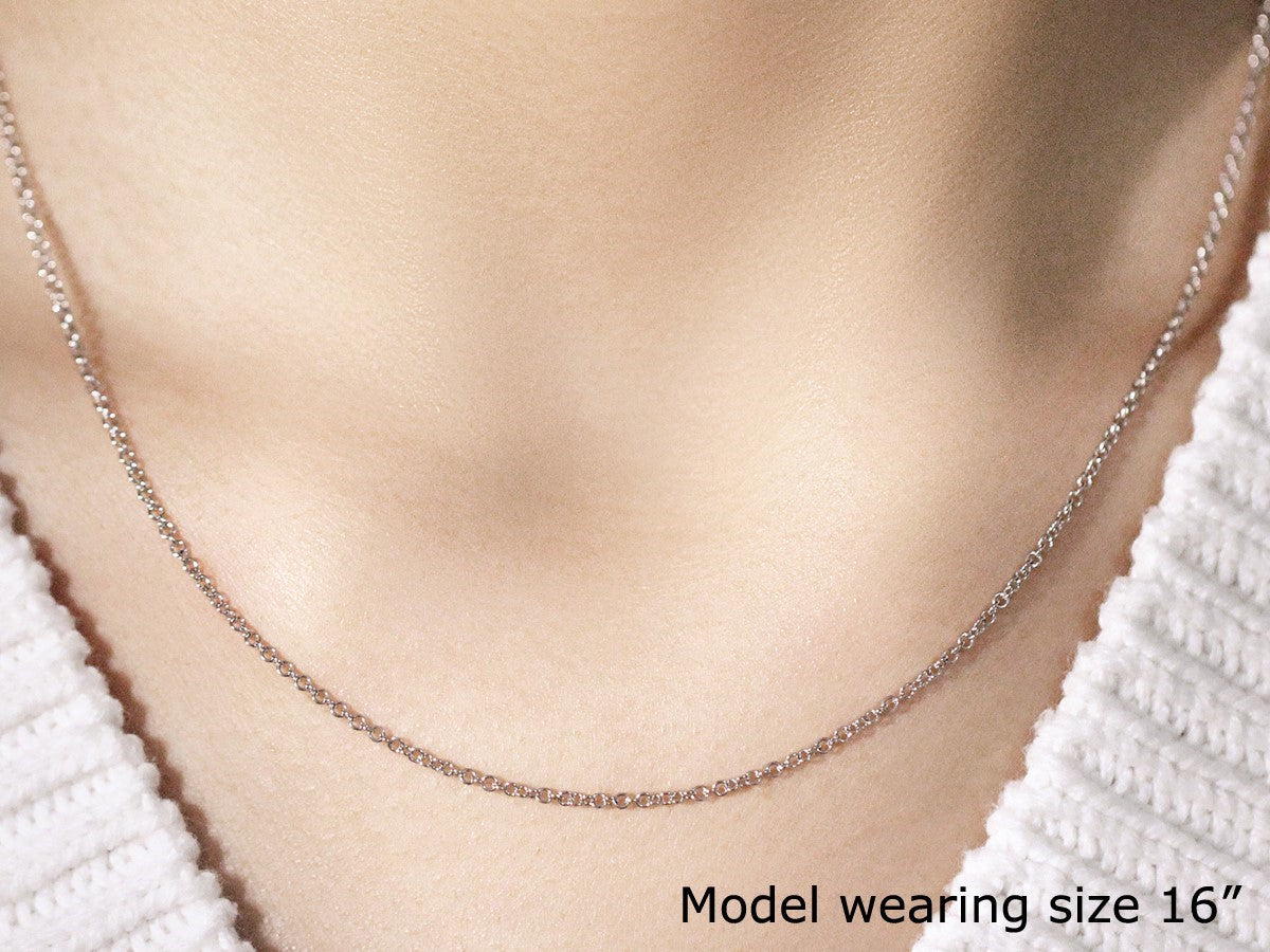 A 14k white gold round cable link chain, 1.50 mm wide, worn by a model.