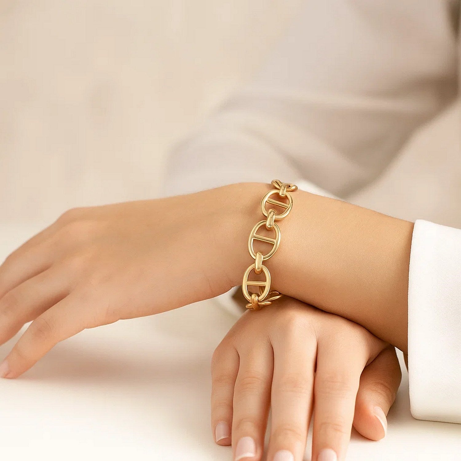 A 14k yellow gold high polish mariner link bracelet on a person's wrist.