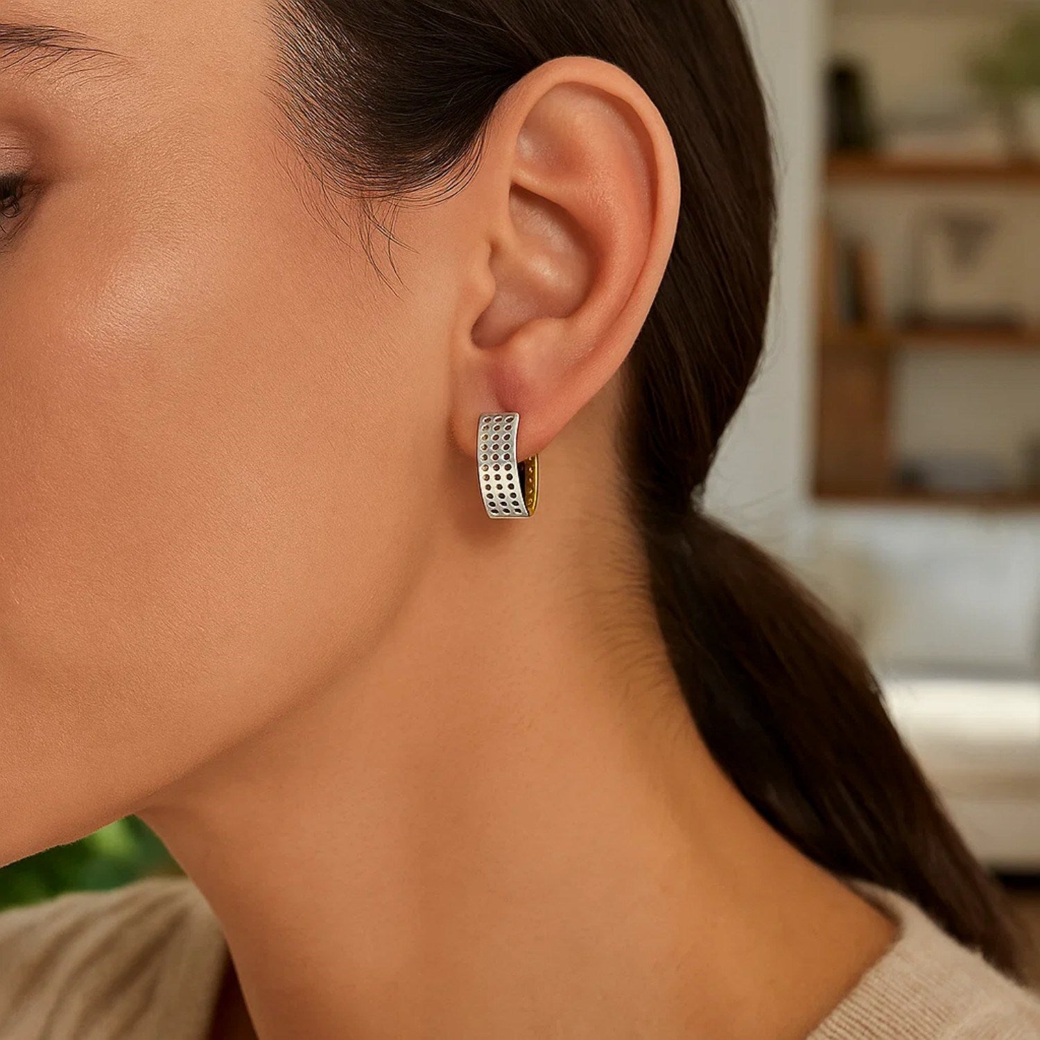 14k two-tone gold snuggable earrings with a mesh style are worn on a woman's ear.