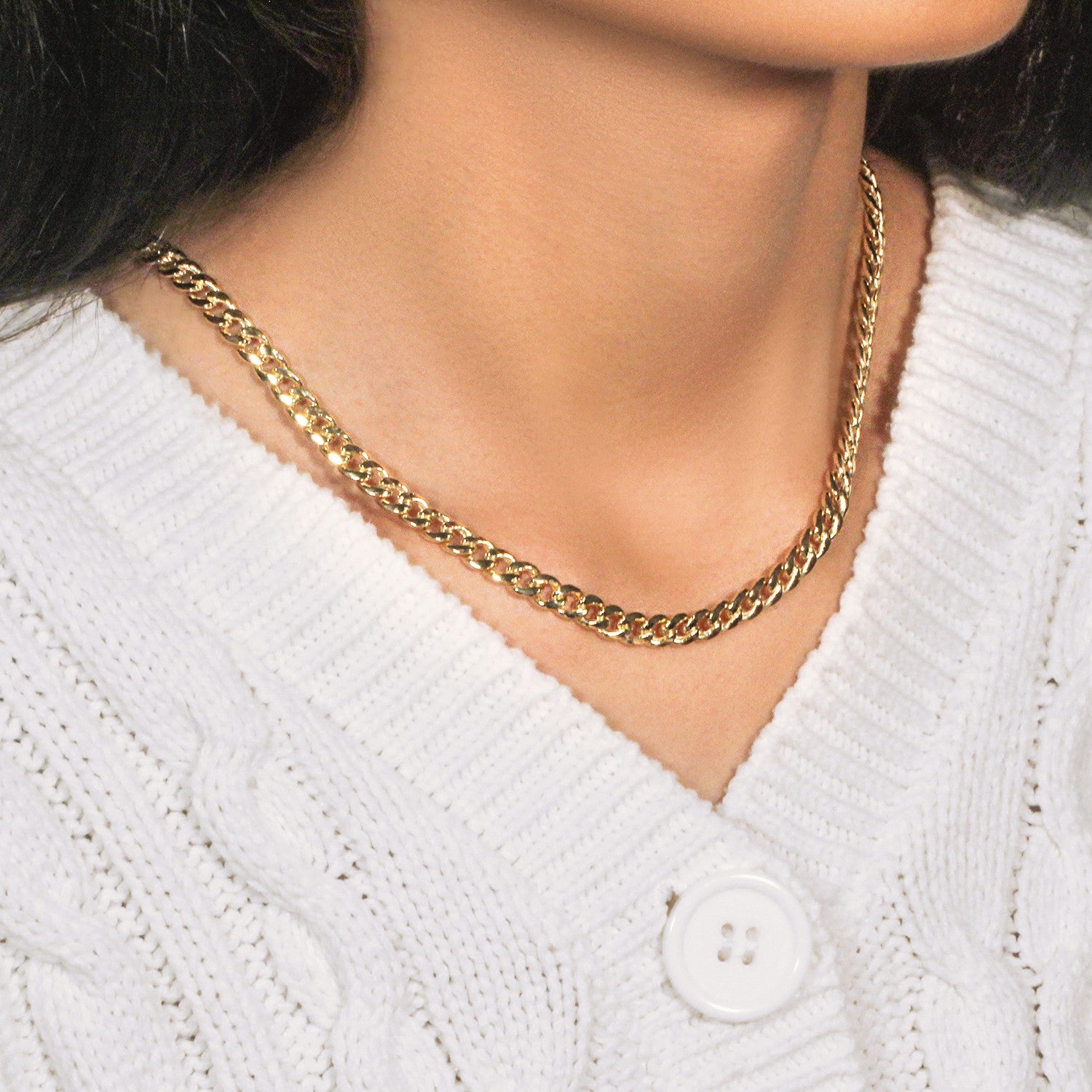 14k yellow gold Miami Cuban semi-solid chain on a person wearing a white sweater.
