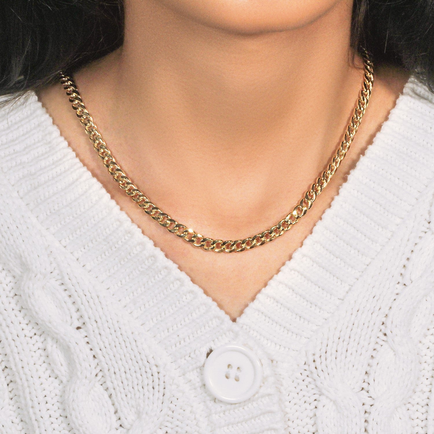 14k yellow gold Miami Cuban semi solid chain on a person wearing a white sweater.