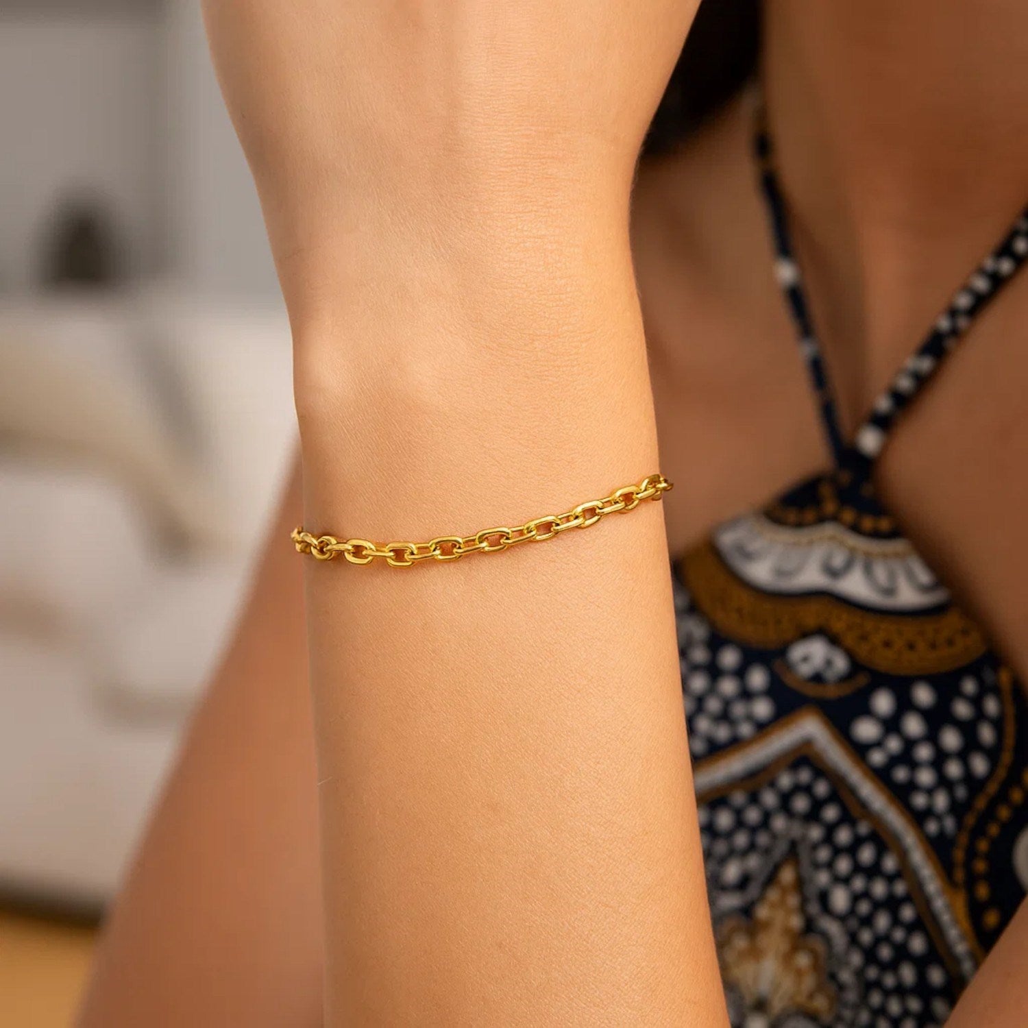 14K yellow gold cable chain bracelet on a person's wrist.