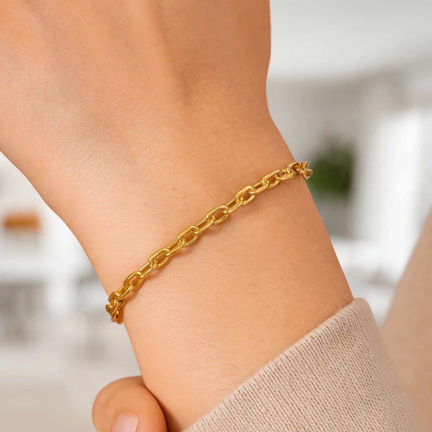 14K yellow gold cable chain bracelet on a person's wrist.
