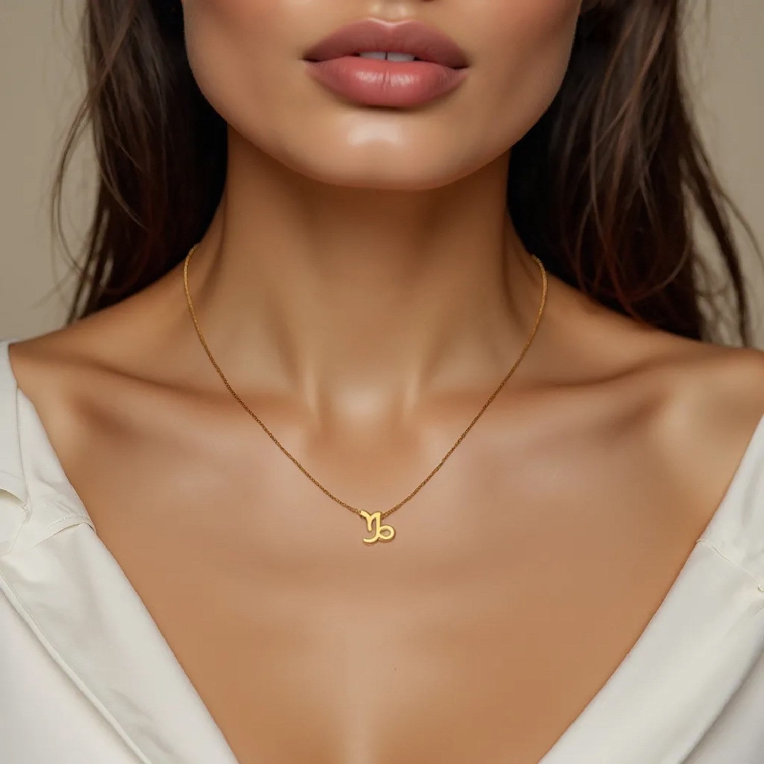 14K yellow gold Capricorn necklace on a woman's chest.