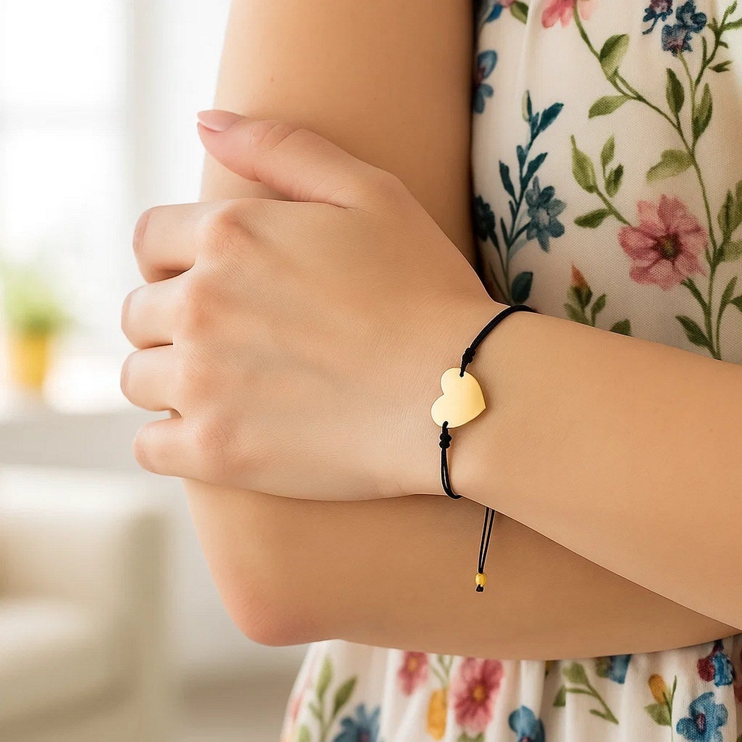Adjustable black cord bracelet with a 14k yellow gold heart charm.