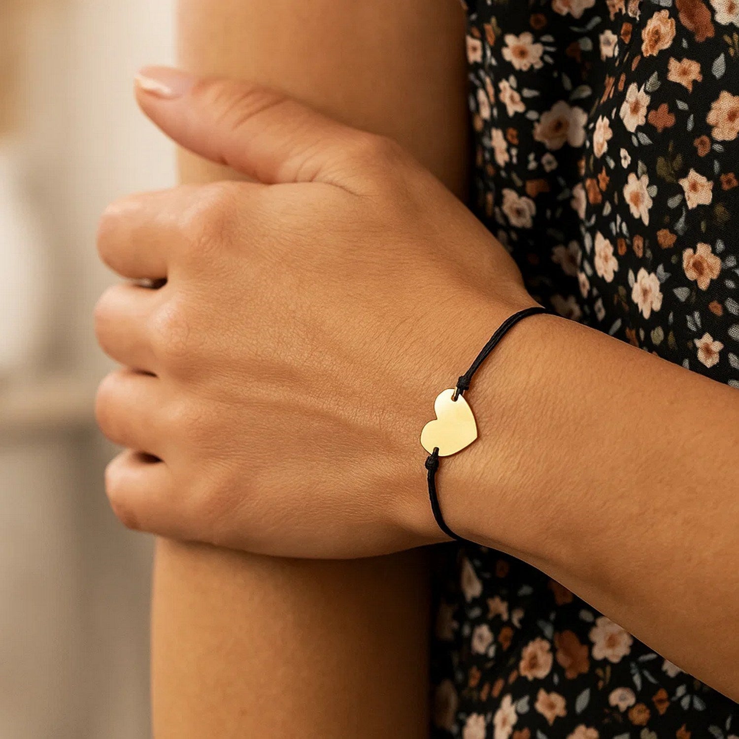 Black cord adjustable bracelet with a 14k yellow gold heart charm.