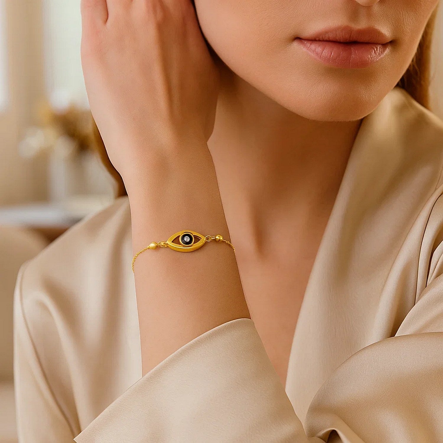 14k yellow gold adjustable evil eye bracelet on a woman's wrist.