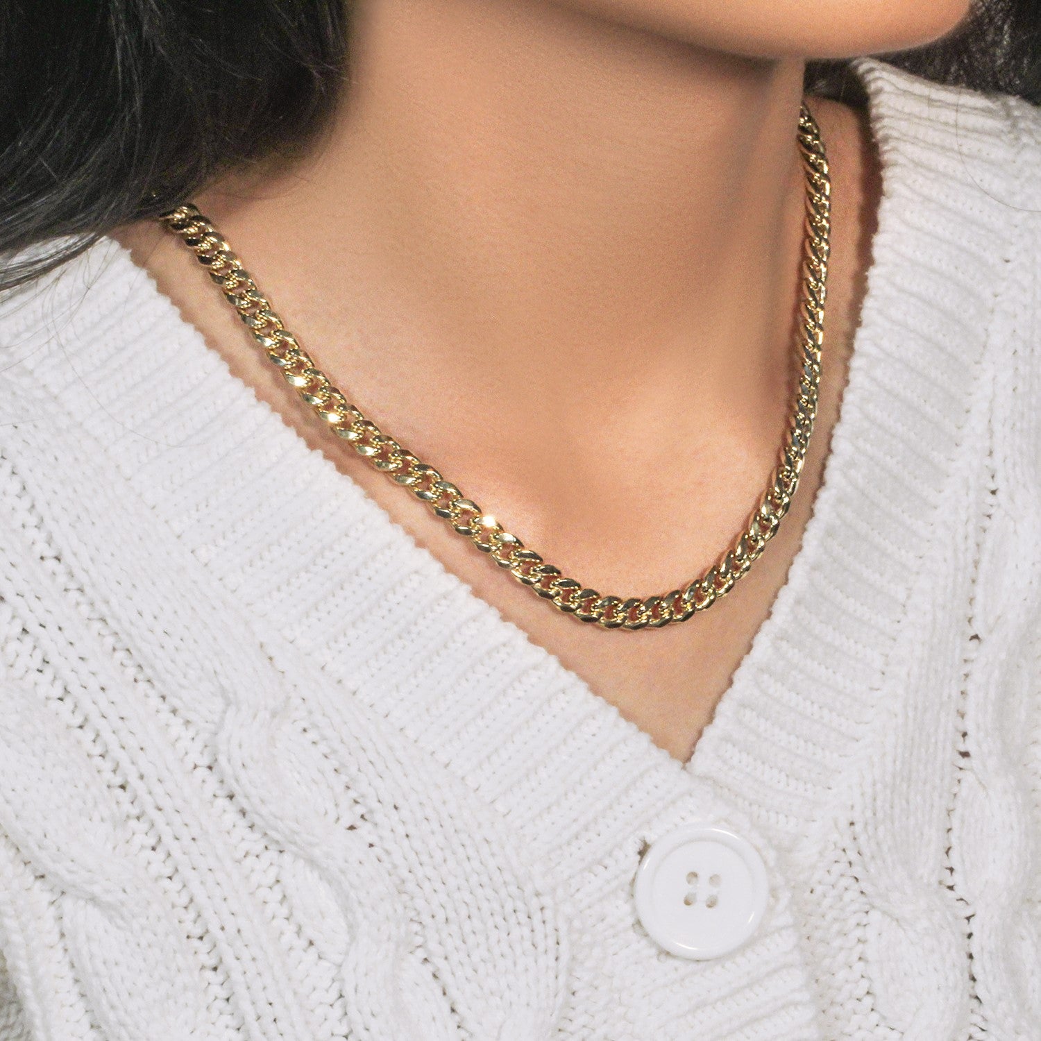 14k yellow gold semi-solid Miami Cuban chain on a person wearing a white sweater.