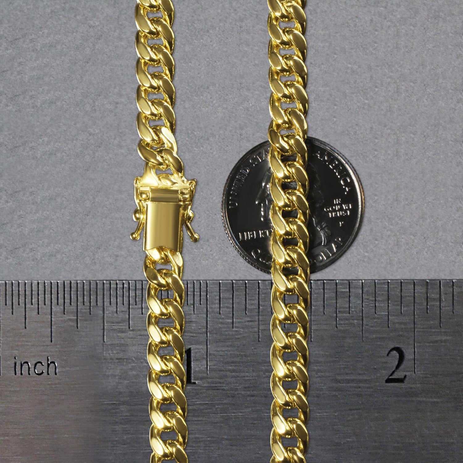A 14k yellow gold semi-solid Miami Cuban chain with a box clasp, shown with a ruler and coin for scale.