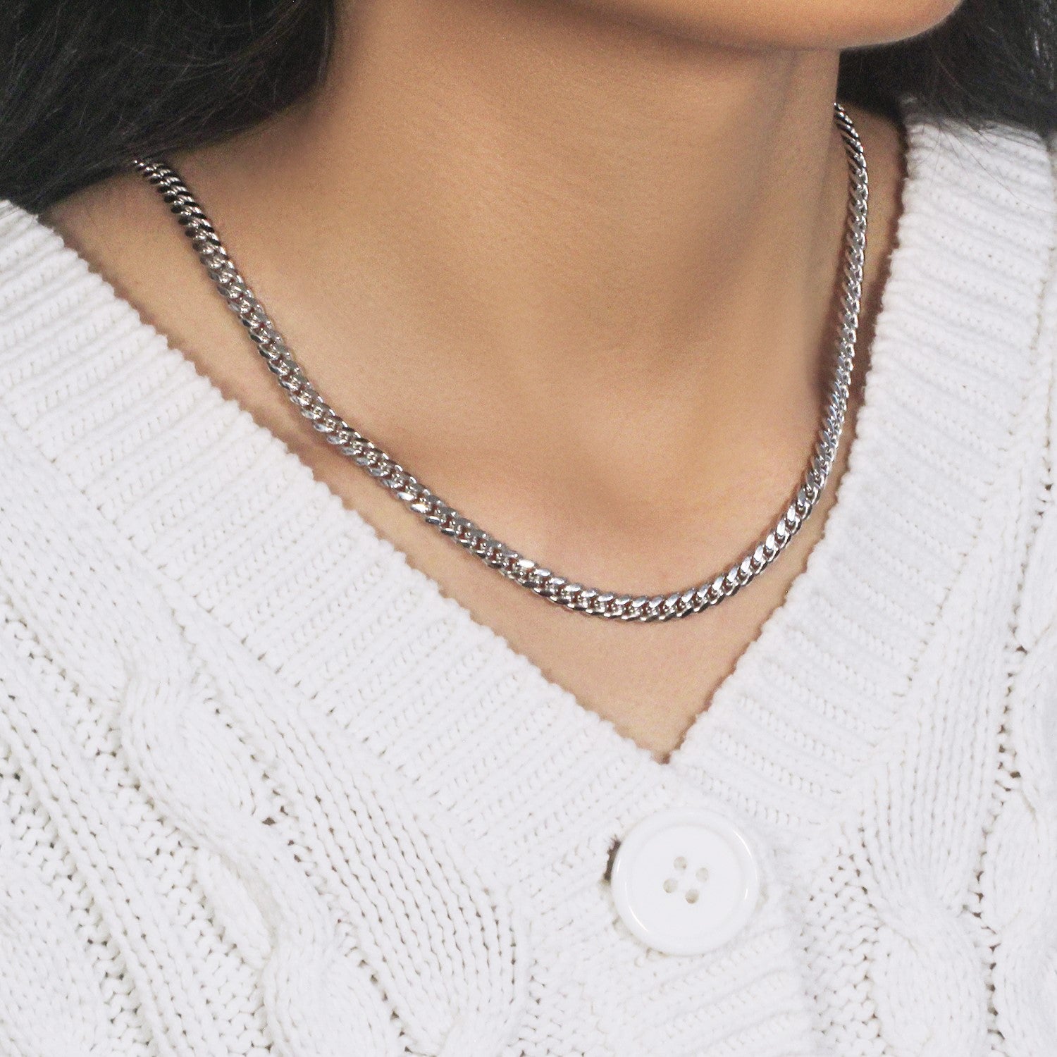 14k white gold classic Miami Cuban solid chain on a person wearing a white sweater.