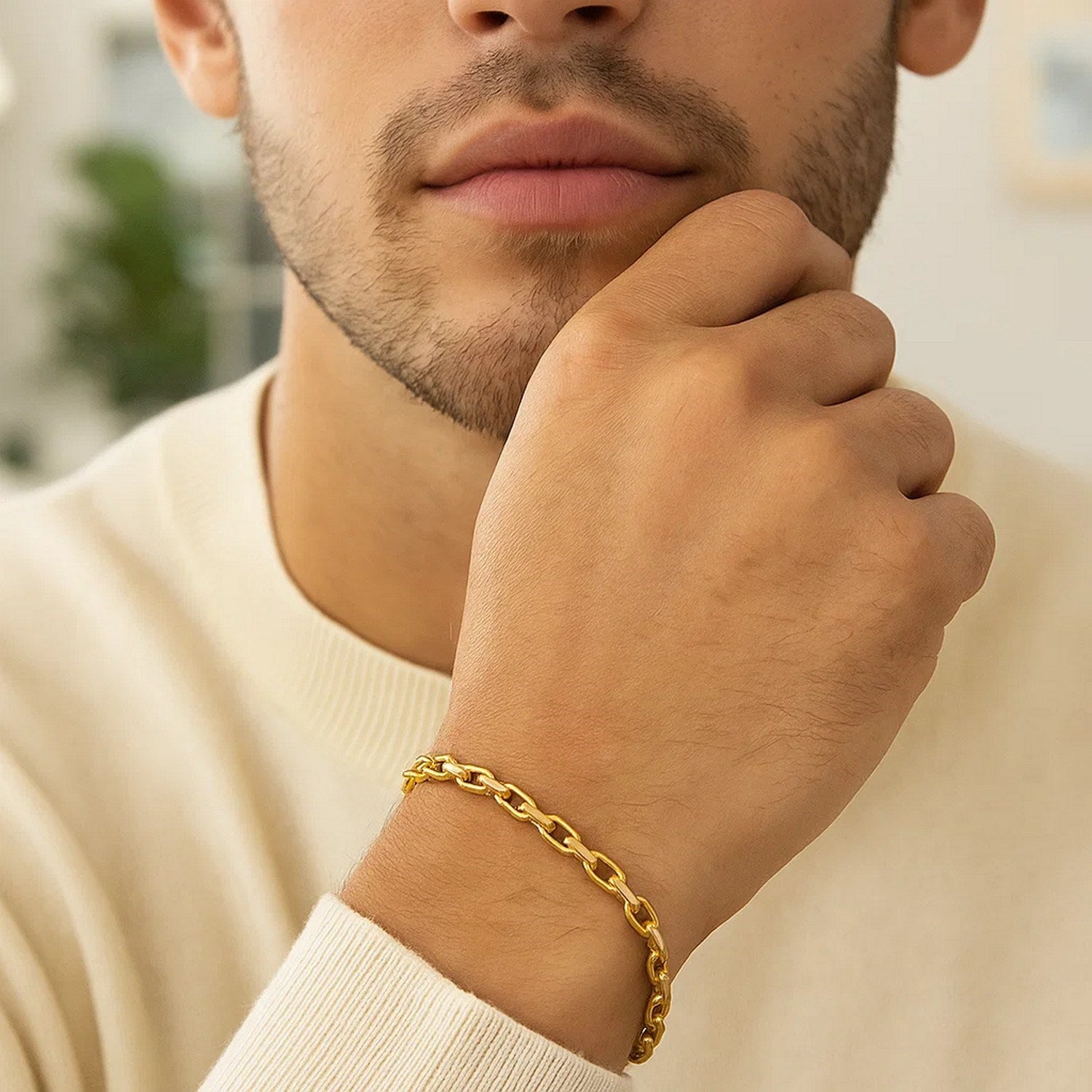 A 14k yellow gold French cable chain bracelet on a man's wrist.