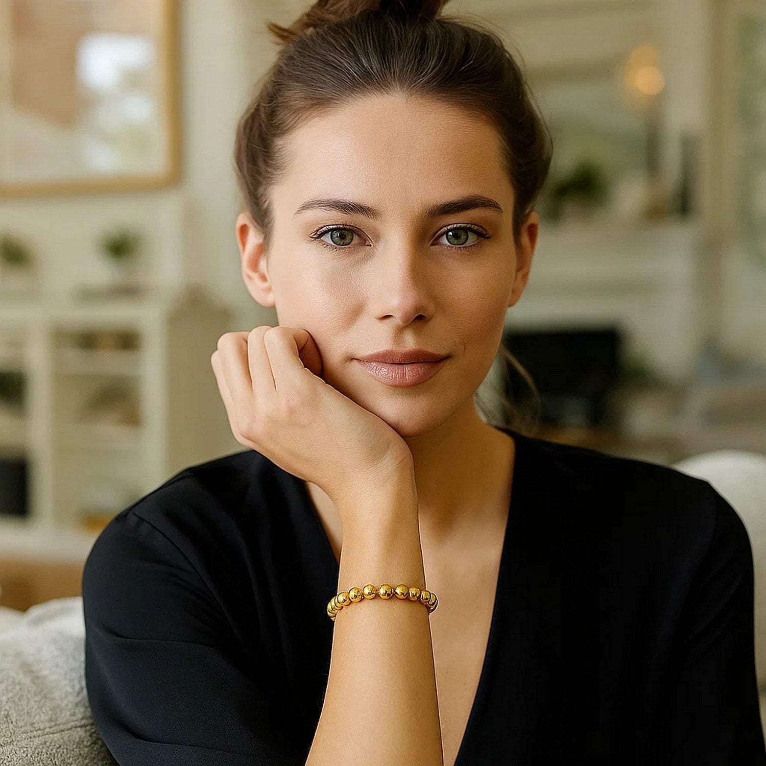 Polished 7mm bead bracelet in 14K yellow gold on a woman's wrist.