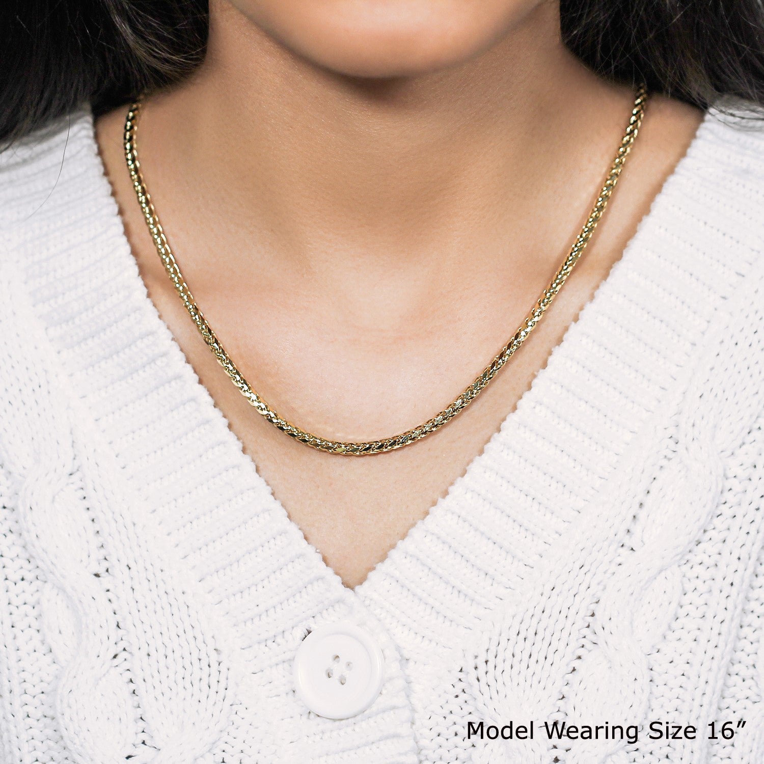 A 14k yellow gold diamond-cut round franco chain on a model wearing a white sweater.