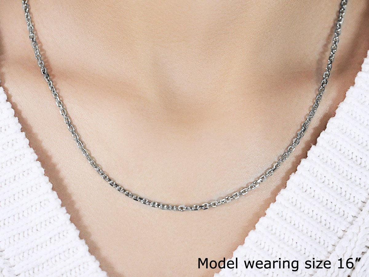 A 14k white gold diamond cut cable link chain is worn around a model's neck.