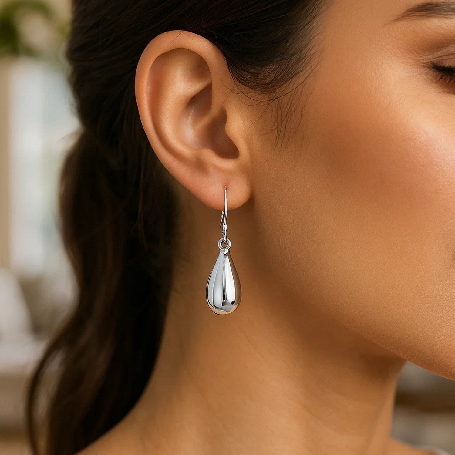 Sterling silver polished puffed teardrop dangle earrings with French wire backings.