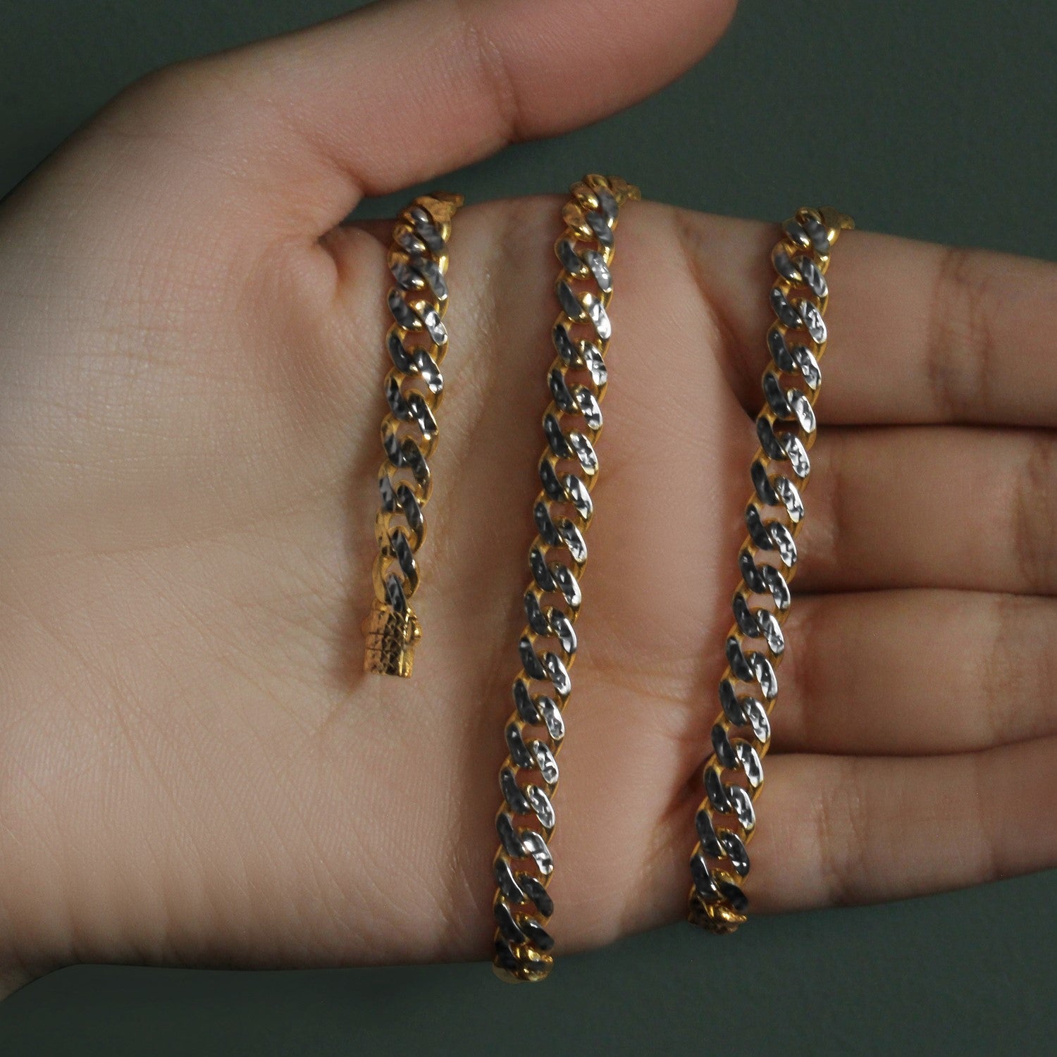 A 14k yellow gold and white pave Miami Cuban chain with a box clasp.