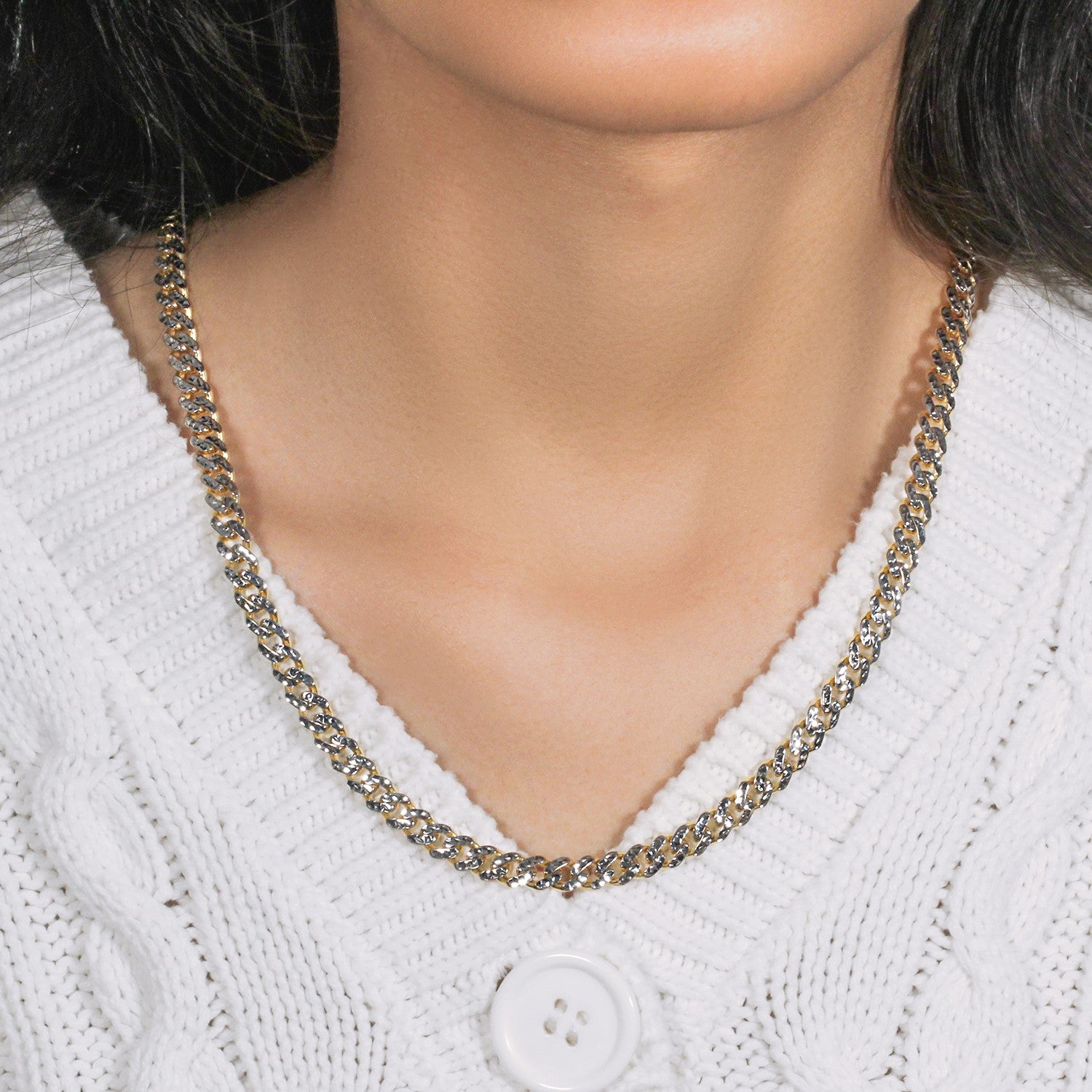 14k yellow gold and white pave Miami Cuban chain on a person wearing a white sweater.