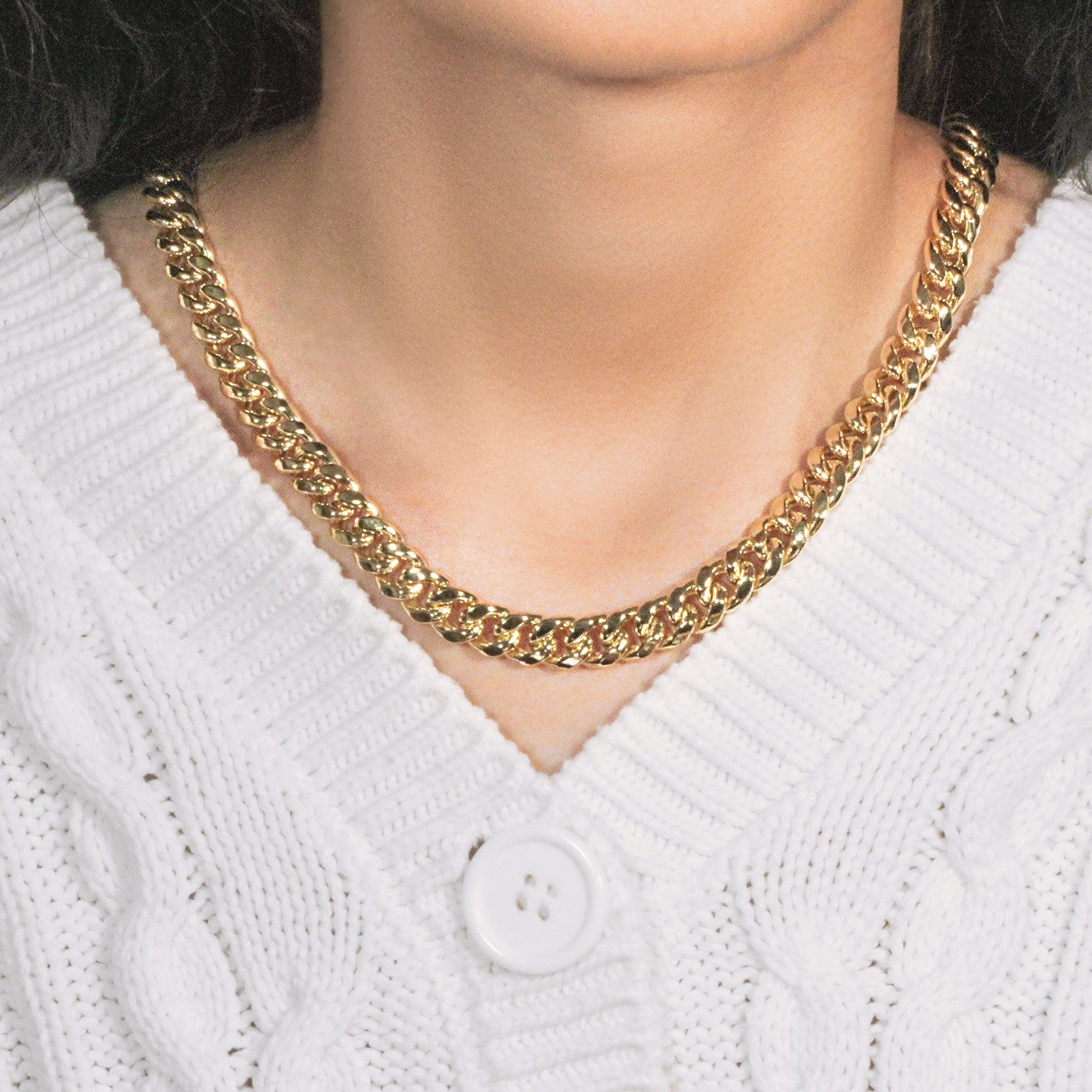 A 14k yellow gold semi-solid Miami Cuban chain, 9.10 mm wide, on a person.