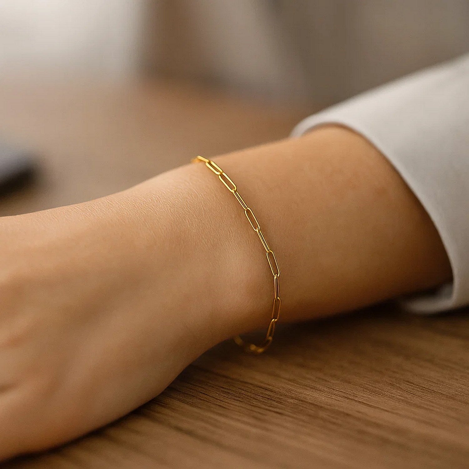 A 14K yellow gold paperclip bracelet with 2.5mm wide links on a person's wrist.