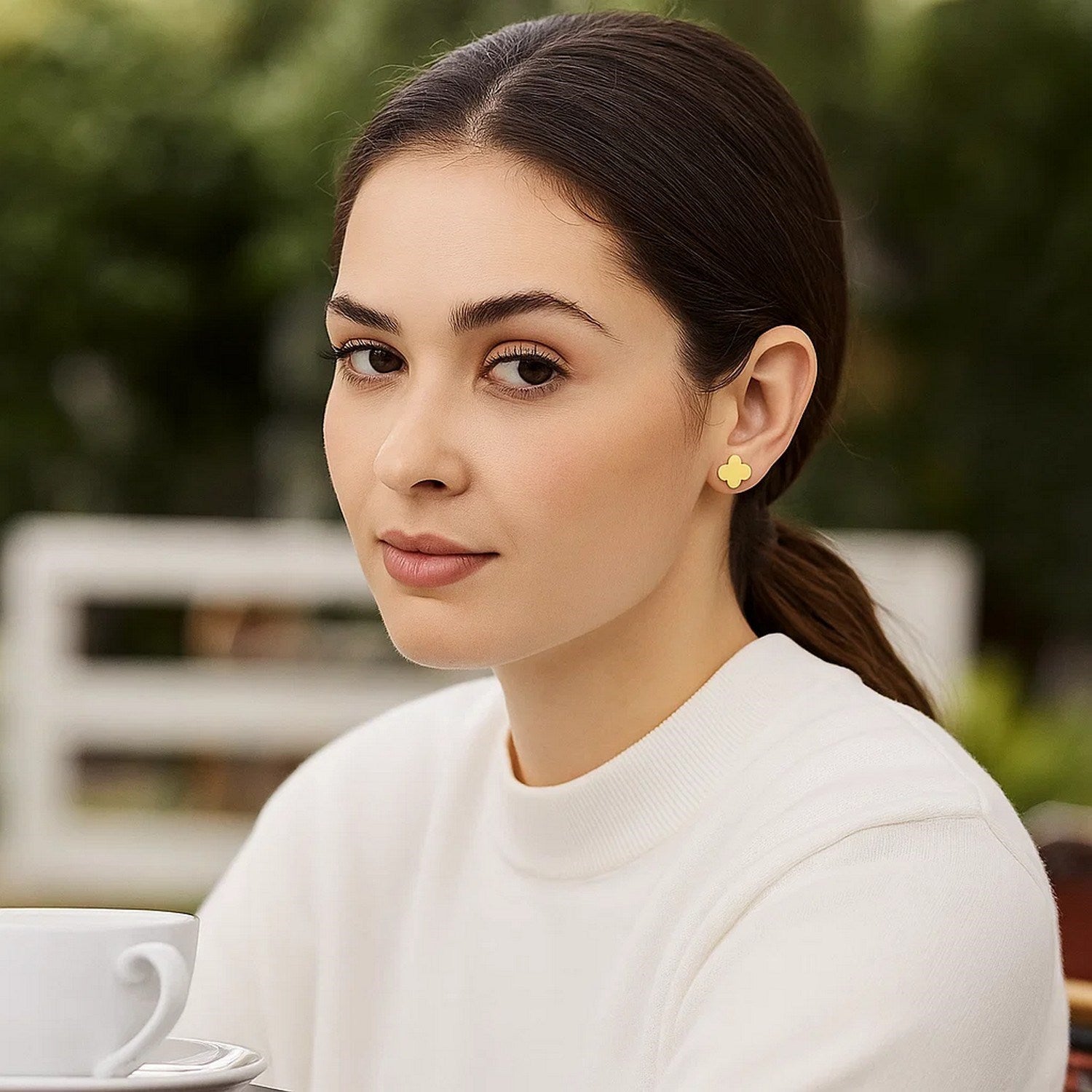 14K yellow gold polished clover stud earrings on a woman.