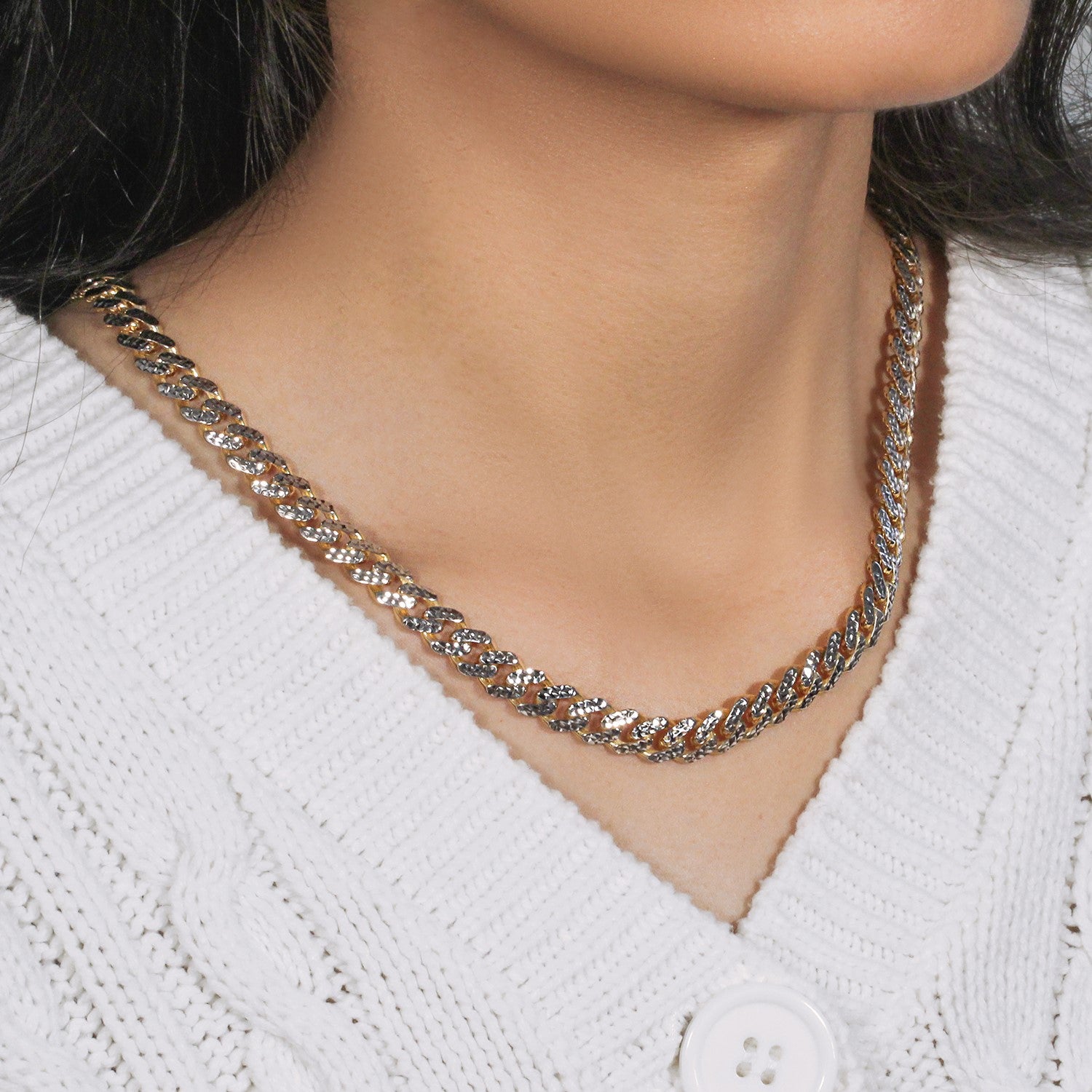 14k yellow gold and white pave Miami Cuban chain on a person wearing a white sweater.