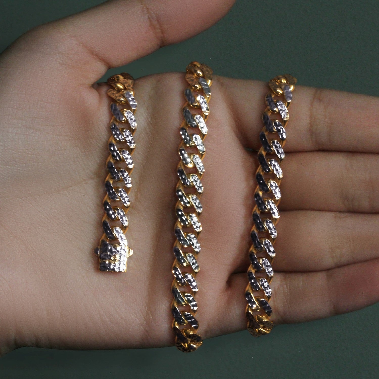 A two-tone 14k yellow gold and white pave Miami Cuban chain with a box clasp.
