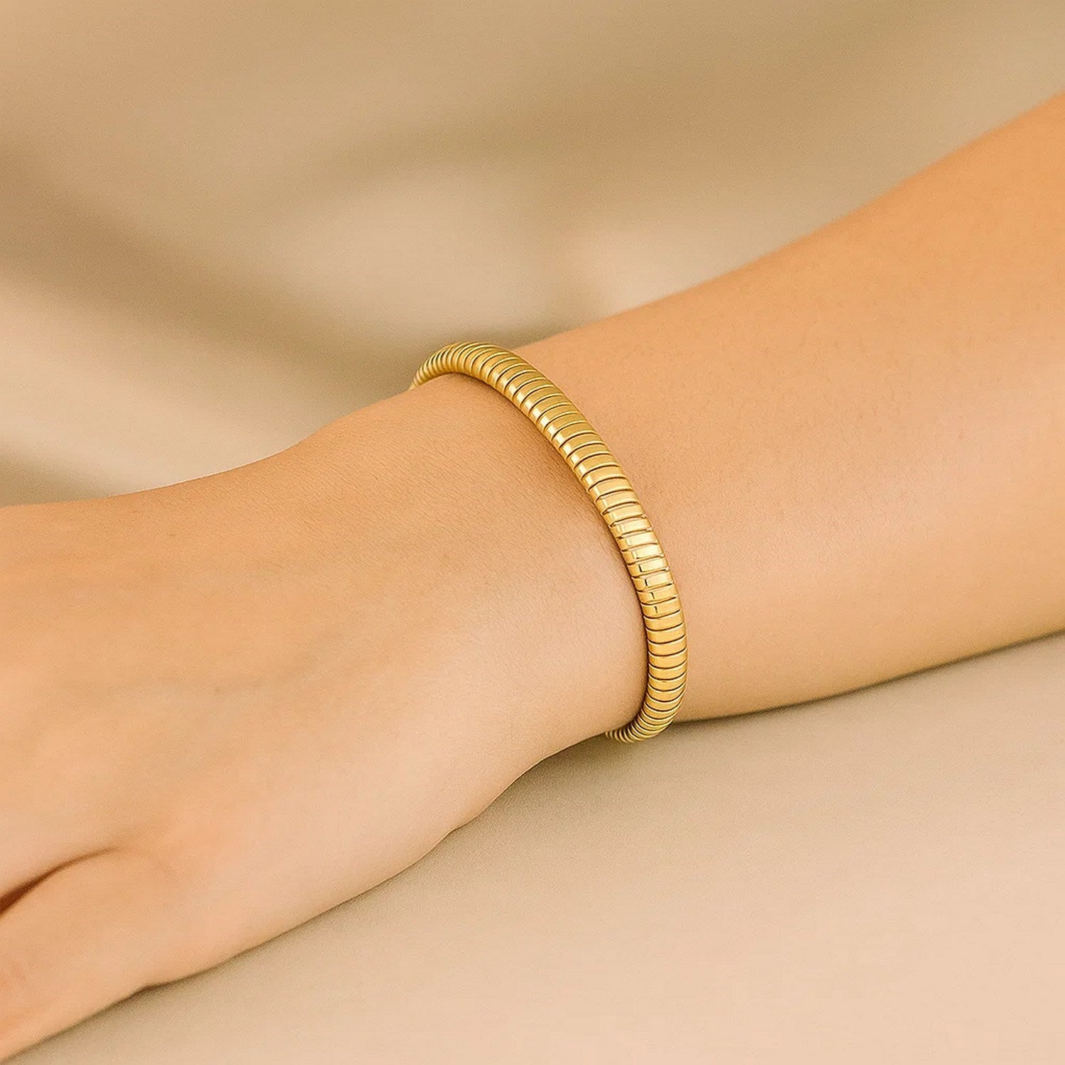 A 14K yellow gold Tubogas bracelet is worn on a person's wrist.