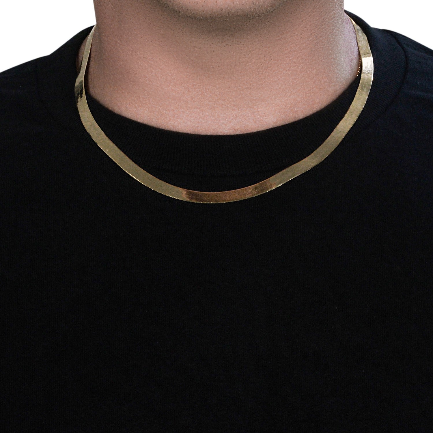 14k yellow gold super flex herringbone chain on a person's neck.