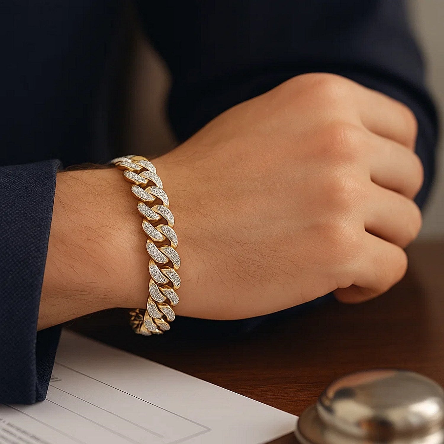 14k two-tone gold curb chain bracelet with diamond pave links on a man's wrist.
