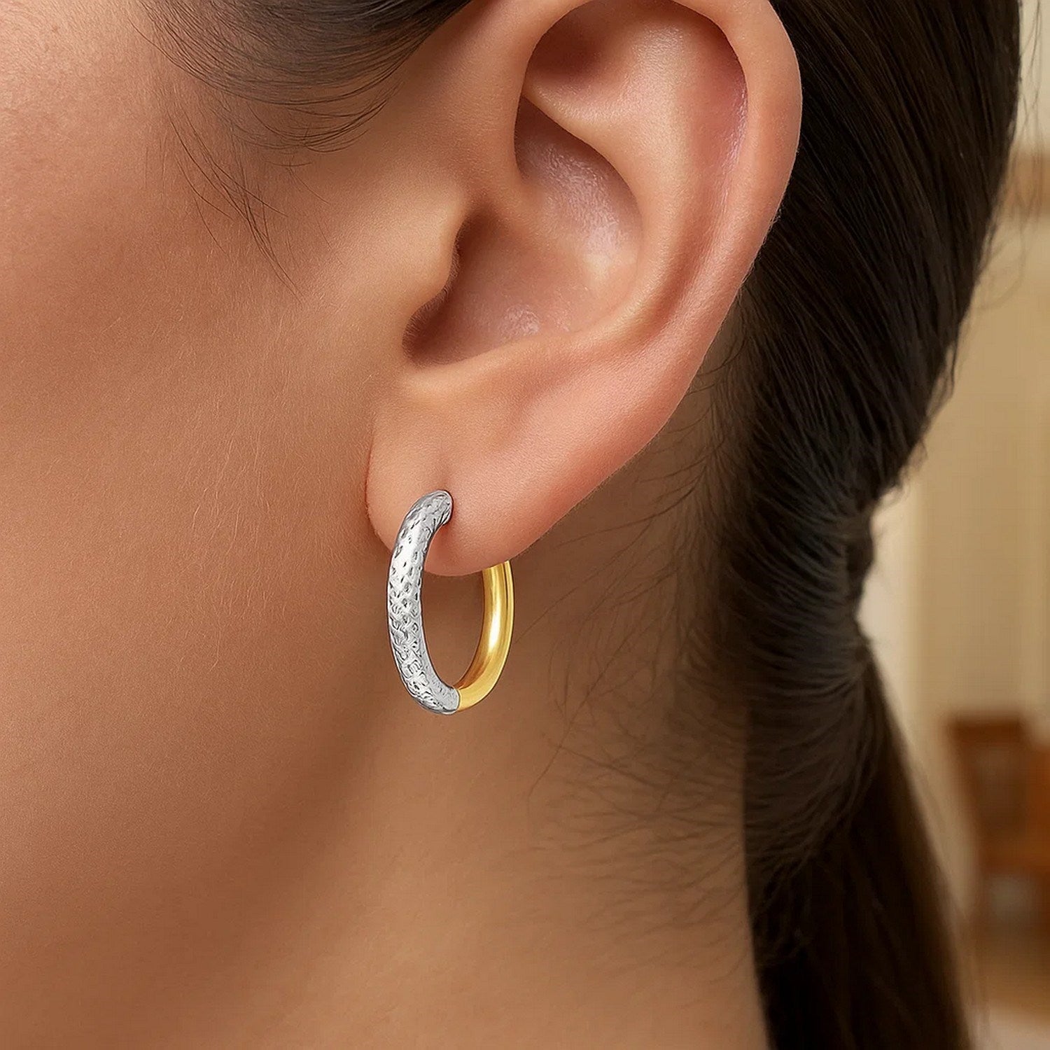 14k two-tone gold hoop earring with a textured white gold and polished yellow gold design.