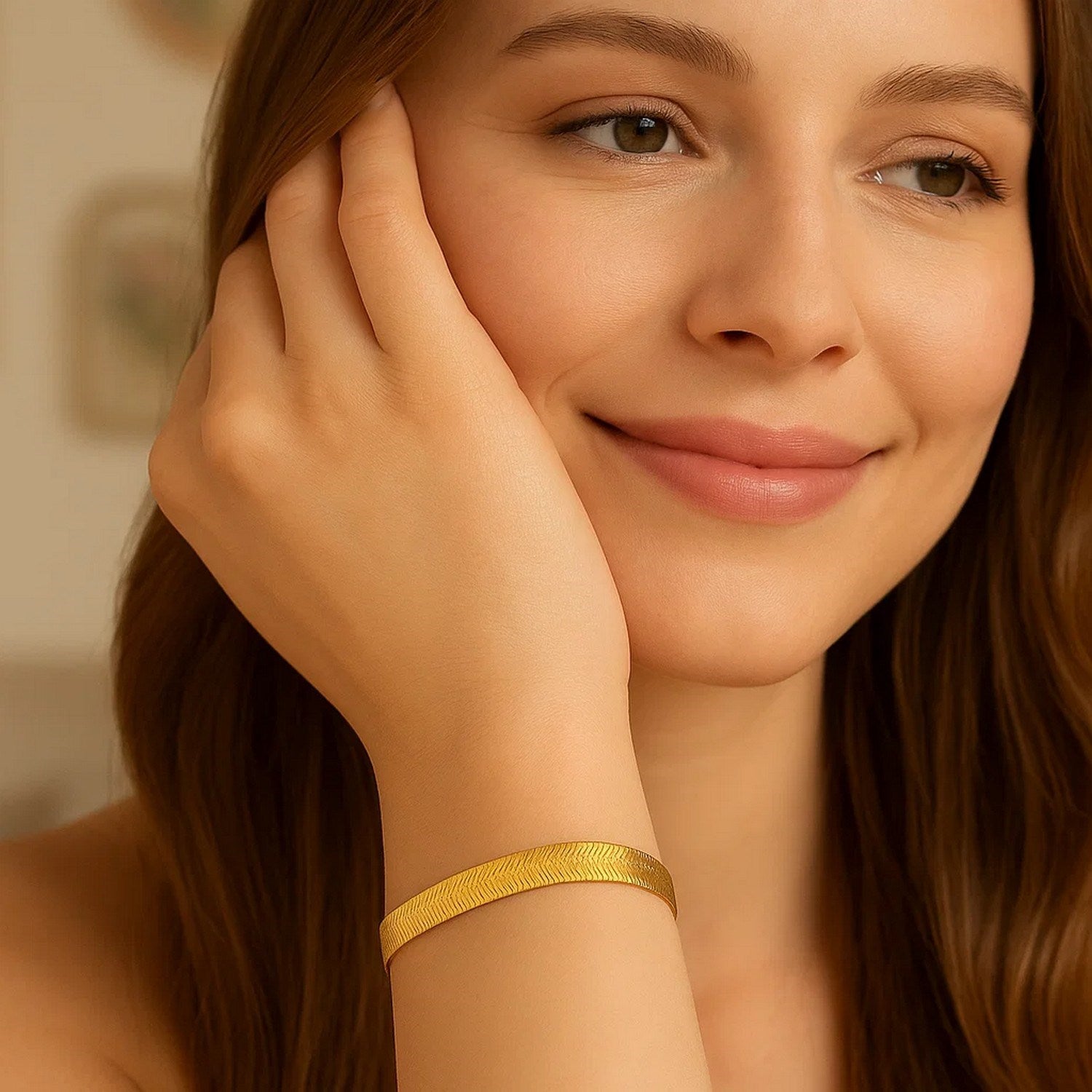 14k yellow gold super flex herringbone bracelet on a woman's wrist.