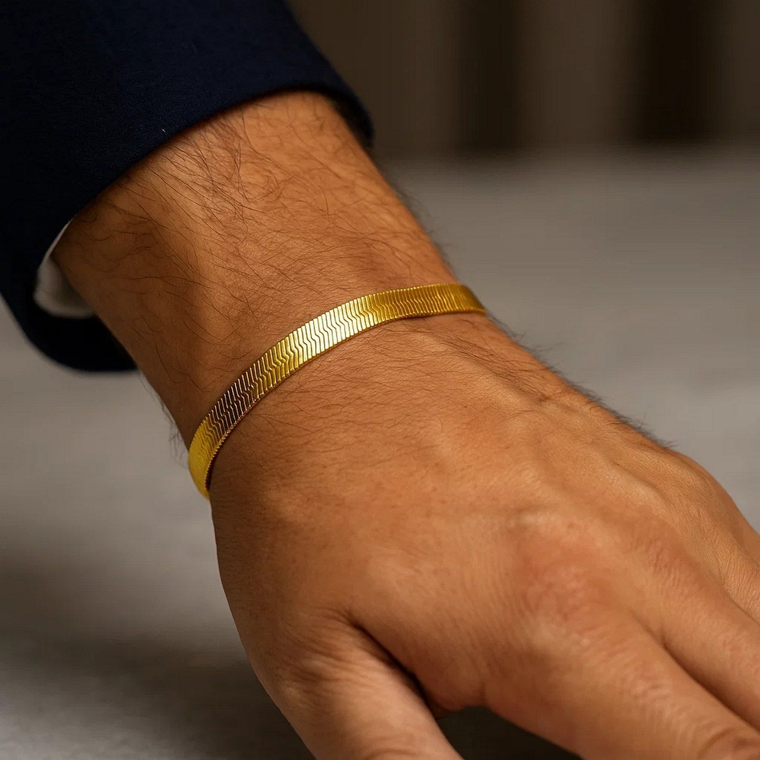 14k yellow gold super flex herringbone bracelet on a person's wrist.