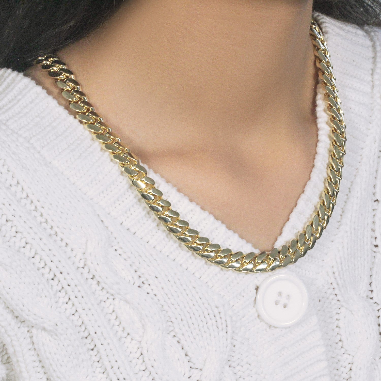 14k yellow gold classic Miami Cuban solid chain on a person wearing a white sweater.