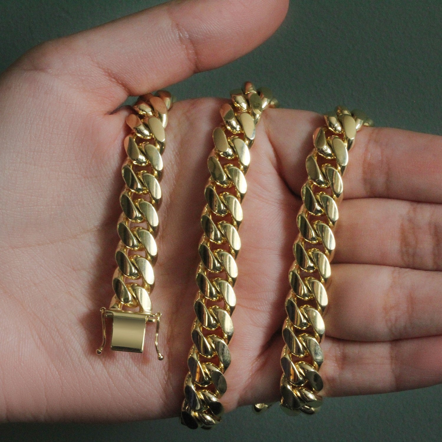 14k yellow gold classic Miami Cuban solid chain, 10.10 mm wide, held in a hand.