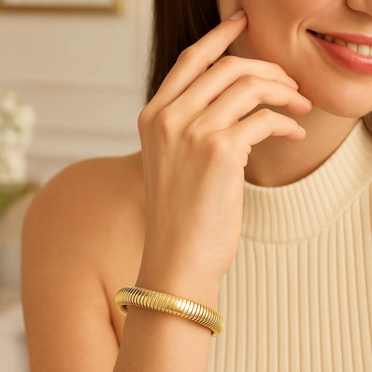 14K yellow gold tubogas bracelet on a woman's wrist.
