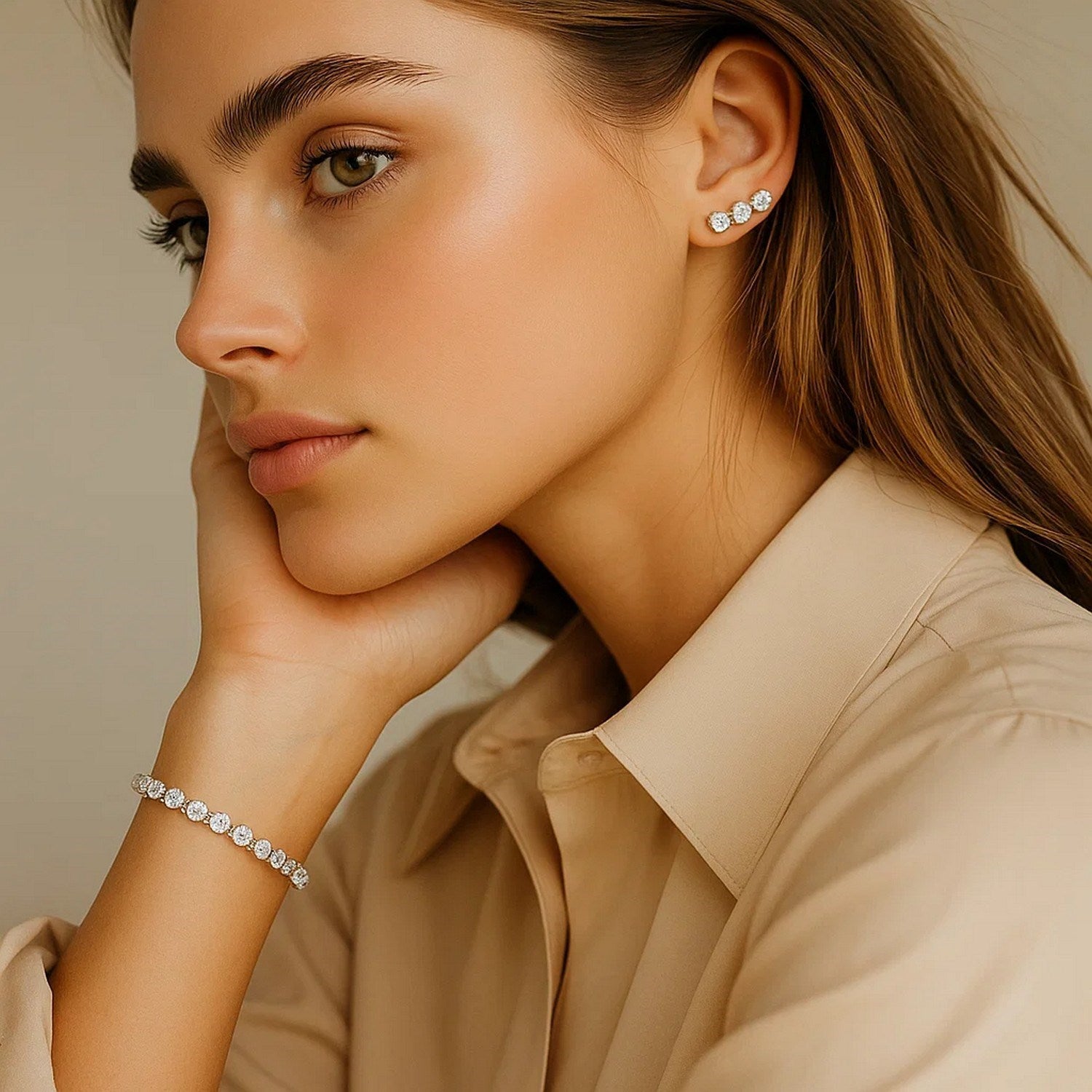 A woman wears a lab grown round diamond tennis bracelet and matching earrings.