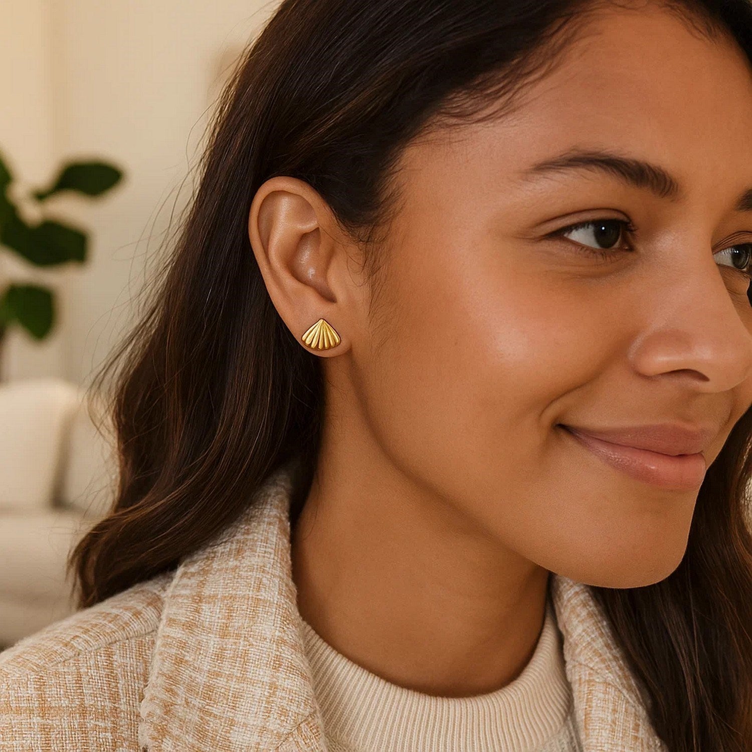 Sea Shell Stud Earrings in 10K Yellow Gold on a woman's ear.