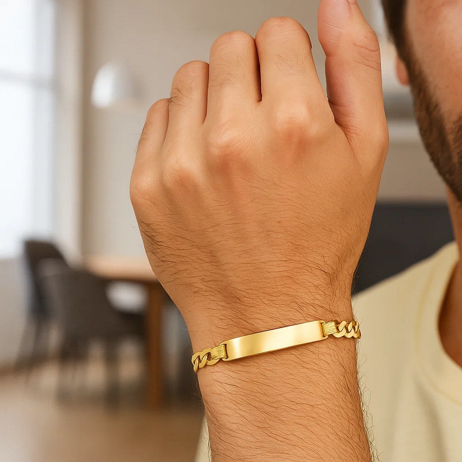 14k yellow gold men's narrow curb chain ID bracelet on a man's wrist.