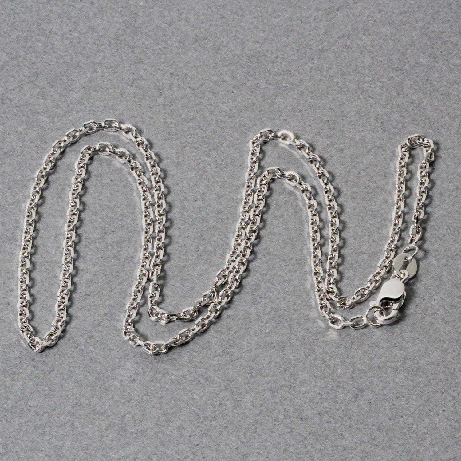 An 18k white gold diamond-cut cable link chain with a lobster clasp.
