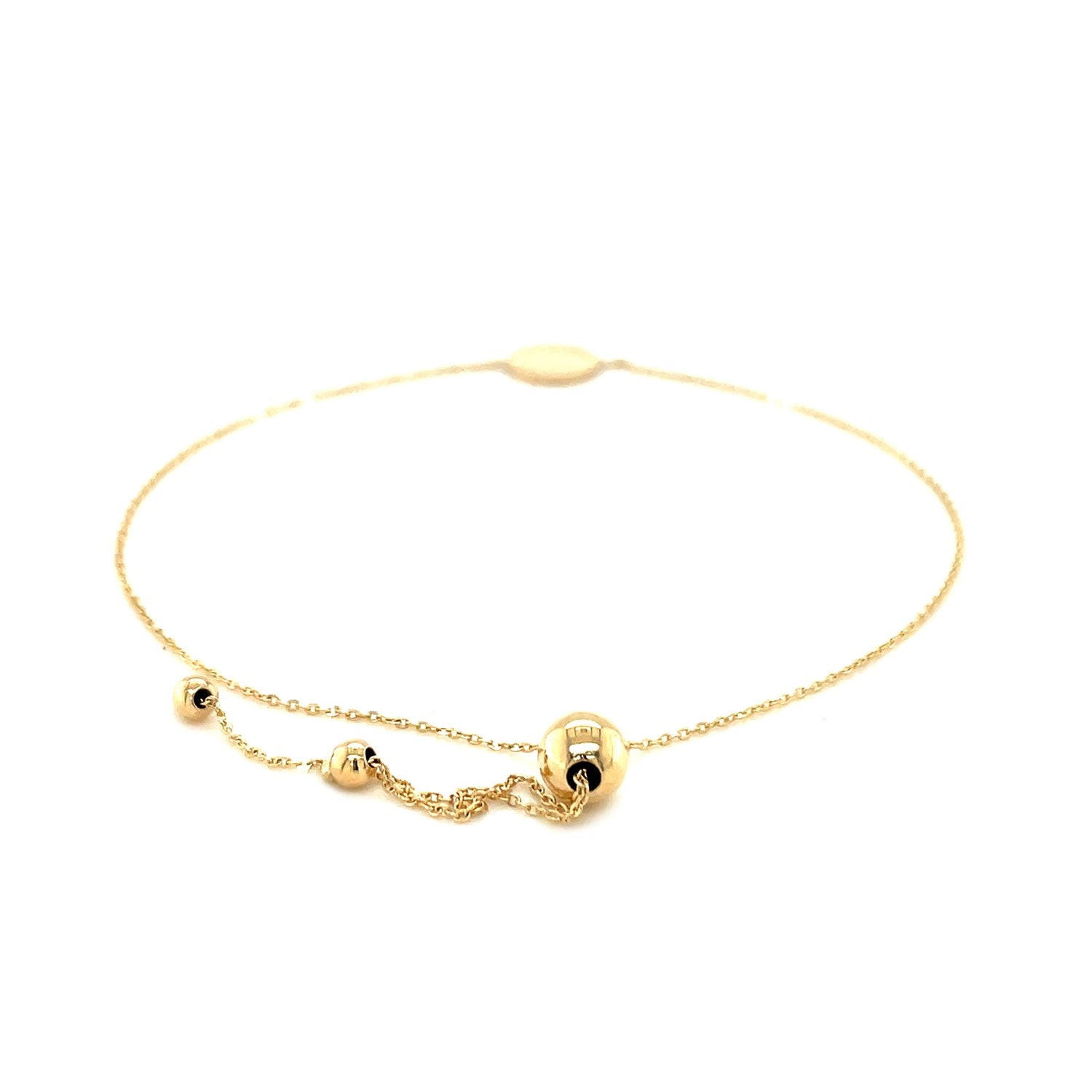 Adjustable 14k yellow gold bracelet with a shiny circle and two small beads.
